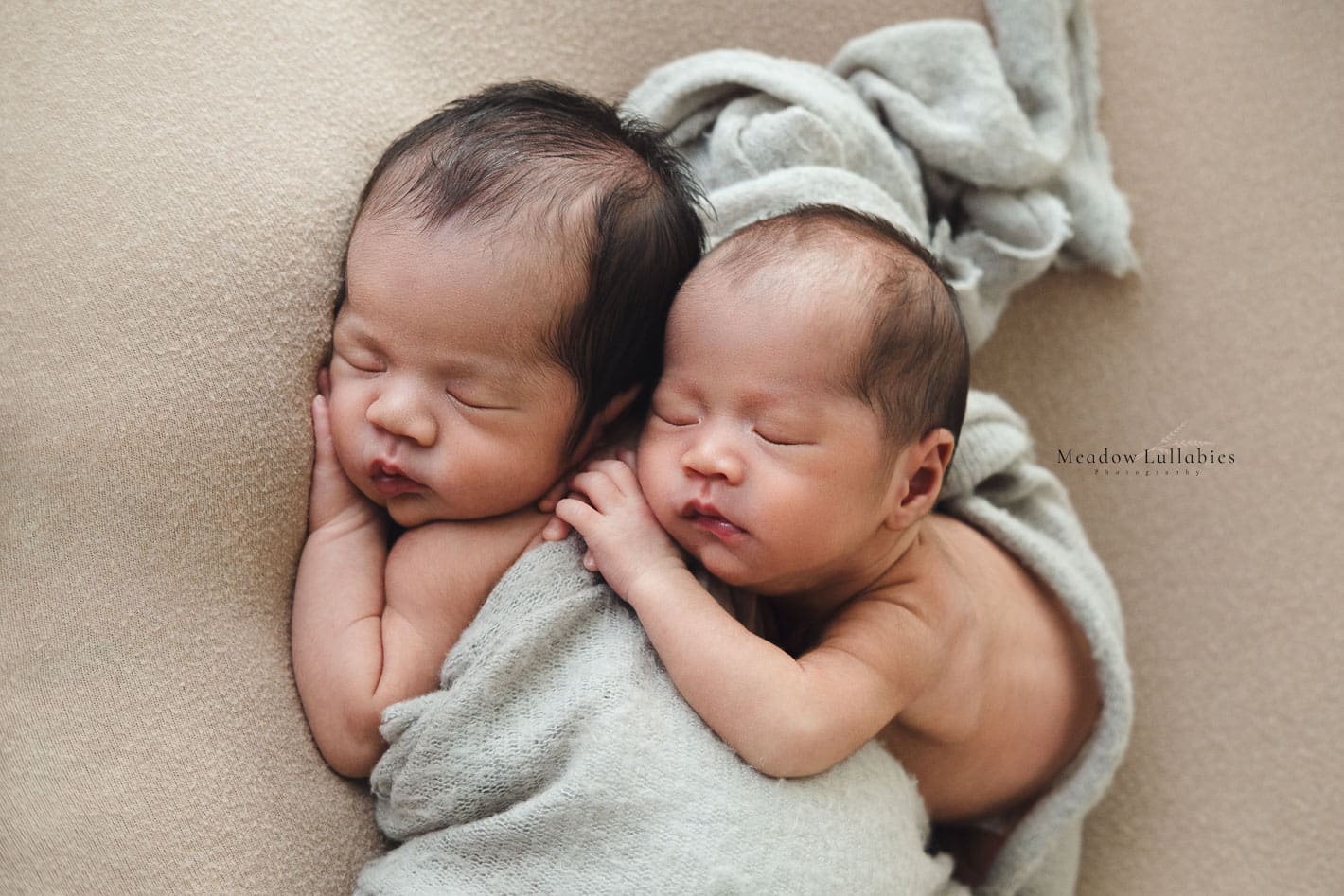 Newborn photoshoot twins laying on each other