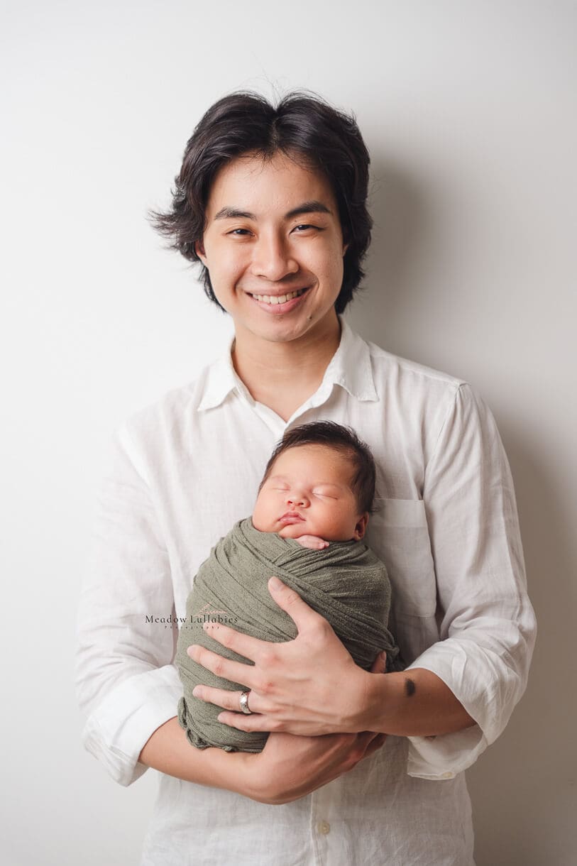 Newborn photography dad posing with his baby girl