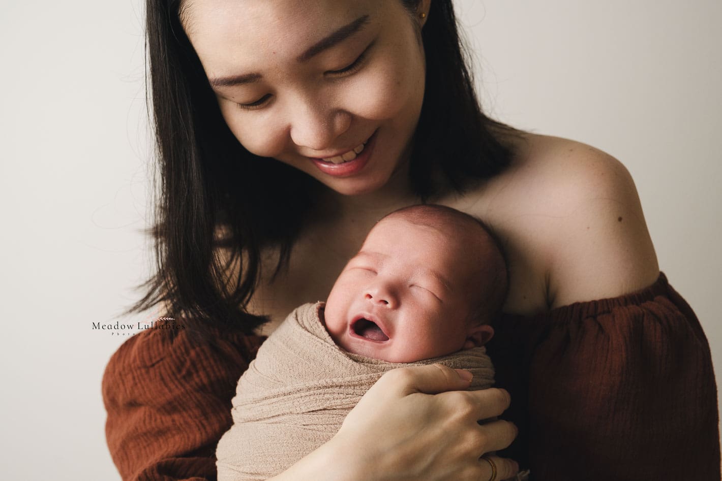 Mom trying to calm her crying baby while posing