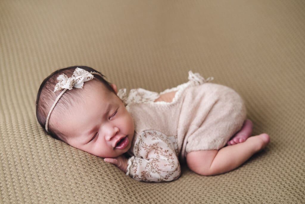 Newborn Photography Singapore | Meadow Lullabies Newborn baby in grey flowery outfit full body shot from the side